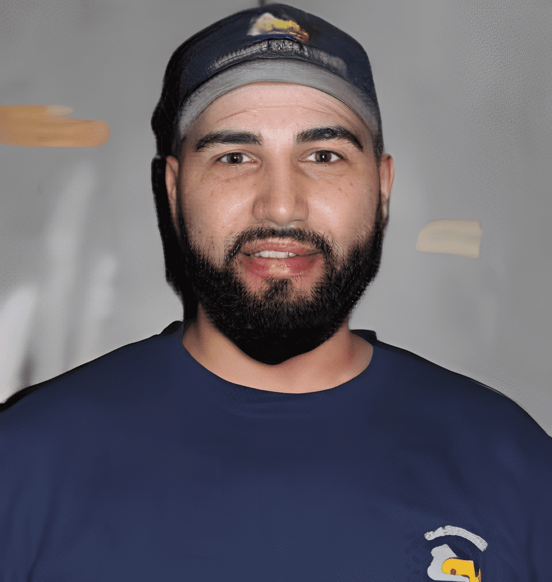 Man wearing a cap and blue shirt