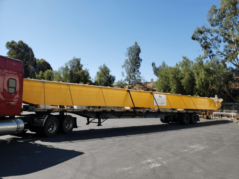 Yellow crane beam on trailer