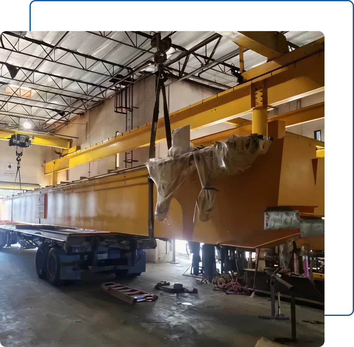 Industrial equipment suspended by crane in factory