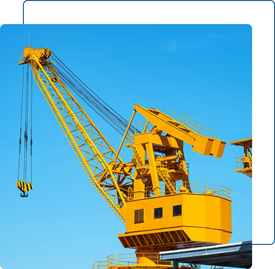Yellow industrial crane against blue sky