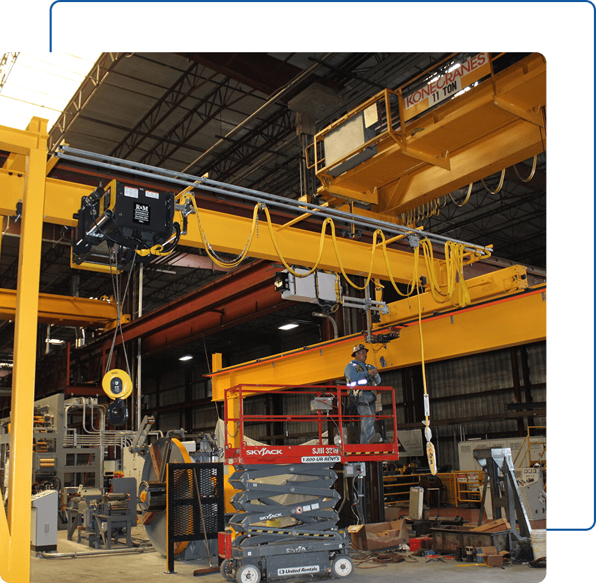 Worker on lift near overhead crane