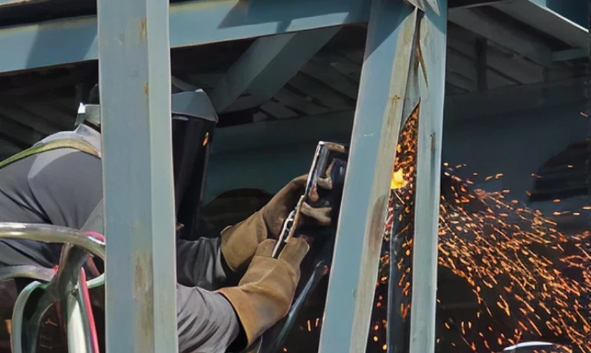 Welding in progress with protective gear.