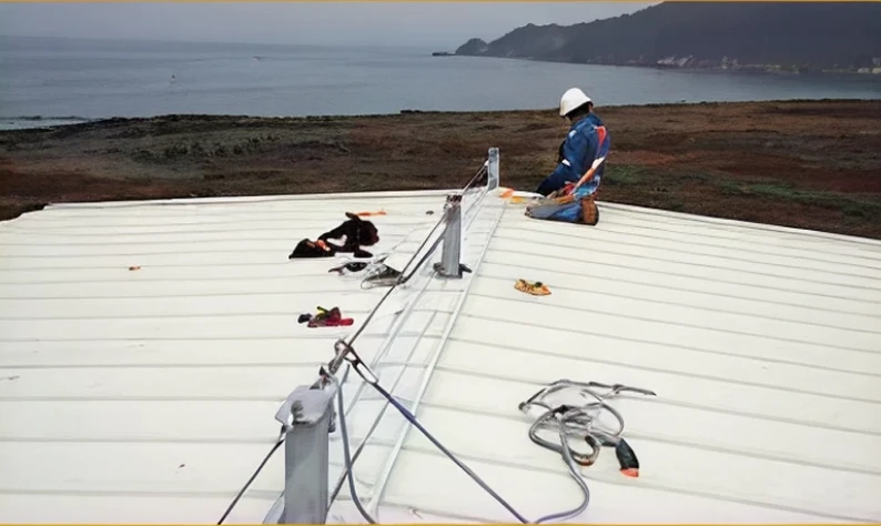 Worker on rooftop with safety gear