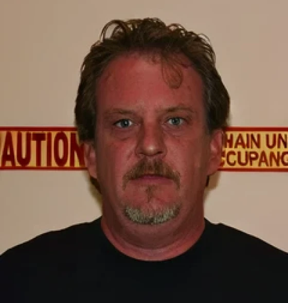Man standing in front of caution sign
